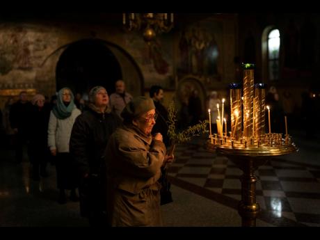 A woman makes the sign of cross during in an Orthodox service celebrating Palm Sunday, in the Holy Trinity Cathedral, in Kramatorsk, Ukraine, on April 17. Celebrations in the Eastern Orthodox Church are a week later than in much of the Christian world.