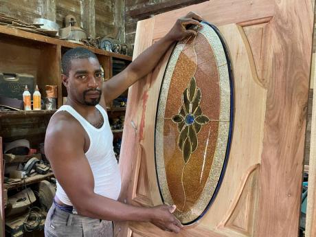 Carpenter Dave Wright shows off the concept for a door he is working on at his workshop inside the old Montpelier train station in St James. Wright will have to find a new location for the business when the plans for the revival of passenger train service 
