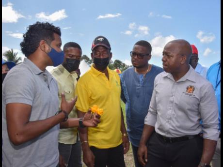 Pearnel Charles Jr (right), minister of agriculture and fisheries, speaks with Alex Sybron (left), chief plant breeding officer, Bodles Research Station, who is displaying one of his products to Councillor Richard Vernon (second left), acting mayor of Mont