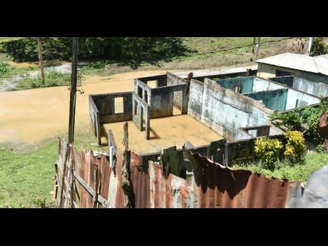 Water settles inside an abandoned building on East Avenue in Linstead, St Catherine, on Wednesday. The residents say decades of complaints to address the flooding problem in the area have fallen on deaf ears.