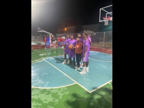 Minister of Culture, Gender, Entertainment and Sport, Olivia Grange (centre), gets set to play a little basketball on the National Stadium’s freshly relayed basketball court during an official opening ceremony on Tuesday.