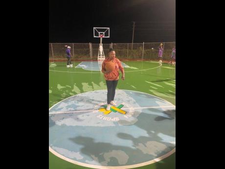 Minister of Culture, Gender, Entertainment and Sport, Olivia Grange (centre), gets set to play a little basketball on the National Stadium's freshly relayed basketball court during an official opening ceremony on Tuesday.