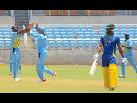 Surrey Royals fast bowler Nicholson Gordon (left) is congratulated by captain Brandon King (centre), following the wicket of Middlesex United Stars captain John Campbell during their Dream XI Jamaica T10 encounter at Sabina Park yesterday.