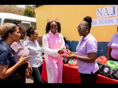 Patsy Edwards-Henry (right), president of the Nurses Association of Jamaica (NAJ), explains the value of healthy Easter eggs for the children to (from left) Danielle Cunningham, corporate communications manager at LASCO; Kanesha Grant-Harvey, Bull Bay Prim