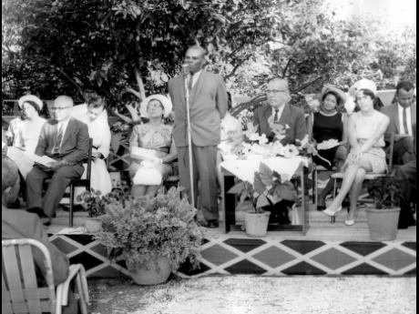 
In this 1967 photo, then Minister of Education, Edwin Allen, gives his address at the official opening of the Clare McWhinnie Memorial Branch Library, Race Course, Clarendon. Seated on platform in the front row are (from left) Mr. C. L. Stuart, Mrs. A. M.