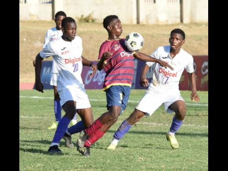 
St Andrew Technical High School’s Omar Laing (centre) draws the attention of the Kingston College pair of Taraj Andrews (left) and Gavin Burton during a Manning Cup football semi-final at the National Stadium East field last season.