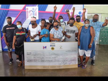 Twelve of the 28 beneficiaries of the $2.9-million grant pose for a photo at the handover ceremony, held at the Denham Town Community Centre, Denham Town, west Kingston, on April 22.