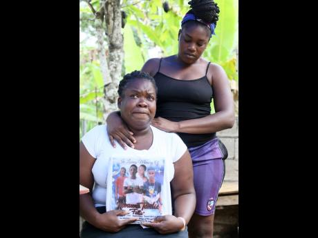 Latoya Anderson Gilfillian is comforted by her sister Sashell Brown,  as she shares memories of her nephew, Kevaun Tomlin.