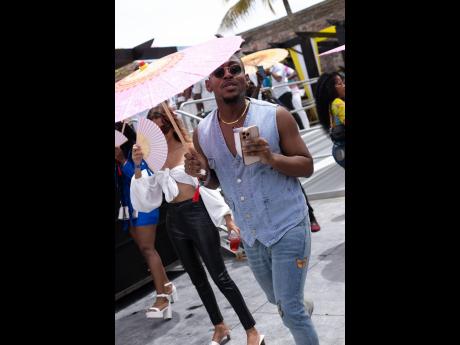 We caught attorney-turned-content creator Rushane ‘Rush Cam’ Campbell moving through the party while sheltering from the blistering sun in this denim look.