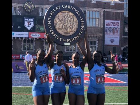 Members of the Edwin Allen High School team celebrate with their plaque after the record run to capture the Championship of America 4x100 metres at the Penn Relays yesterday. From left: Tina Clayton, Brandy Hall, Tia Clayton and Serena Cole. Edwin Allen cl