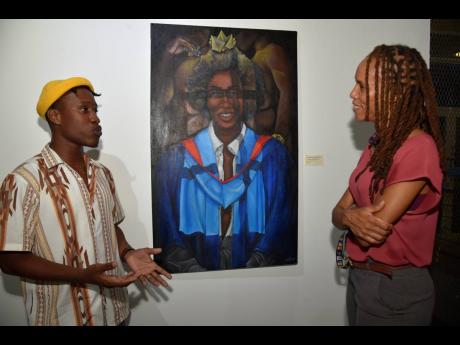 
Jaevon Vassell (left) with his artwork, ‘The Window of Opportunity’, speaks to Kerry-Ann Henry.