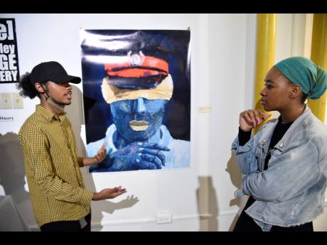 Andrew Cross (left) speaks about his work ‘Nonchalant’ to Tonycia Jarrett at the ‘State of Mind’ art exhibition held at the CAG[e] gallery. 