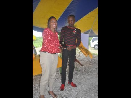 Deidre Hudson-Sinclair (left), director of the Road Safety Unit, makes a presentation to Delgado ‘Dainty’ Smith, a volunteer diver, on Saturday.