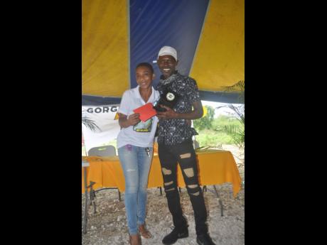 Elorine Smith hands a token of appreciation to Peter Slew at a road-safety event on Saturday. Smith lost her mom, Valerie Ennis, in a Bog Walk Gorge crash last June.