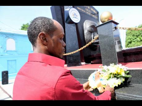 Lionel Francis, father of Yetanya Francis who was murdered in 2018, lays wreath at the Secret Gardens monument in Kingston on Sunday. 