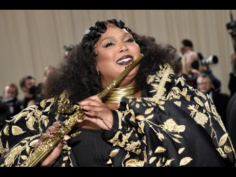 Lizzo brought her flute and donned a Thom Browne gown.