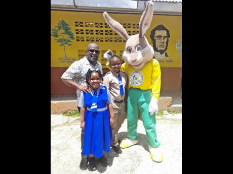Mascot design winner Richard Small (second right) with Mr Protector, the child protection mascot which he designed, along with his dad, Lester Small, and sister, Hillary Small.