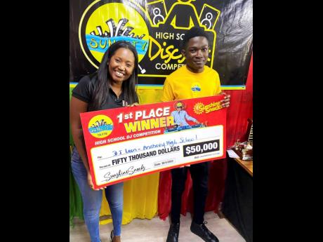 Sunshine Snacks brand manager, Shantel Hill-Afonso, hands over a $50,000 cheque to the winner of the 2022 SunCity 104.9 FM’s High School Disc Jock Competition, Leon ‘DJ Leon’ Vassell.
