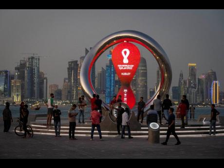 People gather around the official countdown clock showing the remaining time until the kick-off of World Cup 2022 in Doha, Qatar.. 