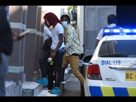 Two alleged members of the notorious One Don Gang enter the Supreme Court building on Monday. One Don is a breakaway faction of the Clansman Gang.
