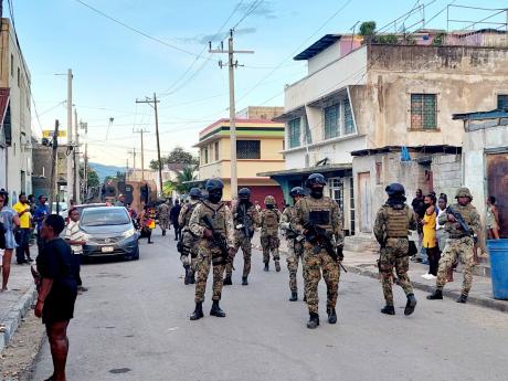 Soldiers on duty in Denham Town, Kingston, on Thursday amid heightened tension following a number of clashes with residents in recent days.