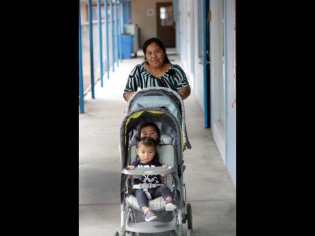 Maria Juarez, a Guatemalan mother from San Marcos picks up one of her children and the child of another worker at the Redlands Christian Migrant Association’s Rollason Child Development Center in Immokalee, Fl.   