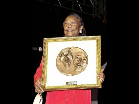 Sonia Pottinger holds up an award she received at the The Prime Minister’s Independence Gala in 2006.