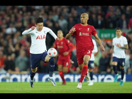 
Tottenham’s Son Heung-min (left) runs with the ball past Liverpool’s Fabinho during the English Premier League soccer match between Liverpool and Tottenham Hotspur at Anfield stadium in Liverpool, England, yesterday.