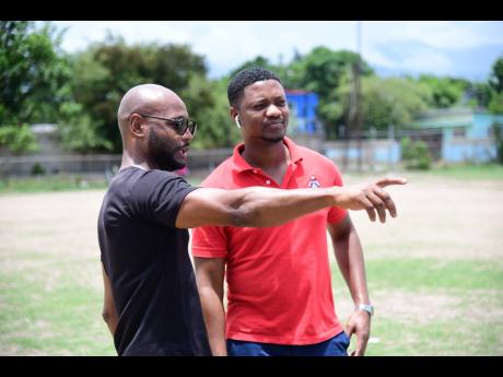Boxing coach Sakima Mullings (left) and Christopher Jackson (Student, University of the West Indies Faculty of Sport) in dialogue as renovations were taking place at the Suga Knockout Boxing Gym at The Olympic Gardens Football Club yesterday.