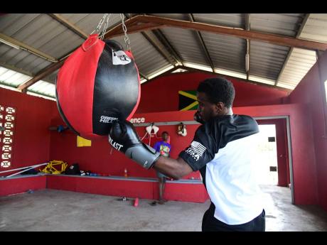 
Jiovani Hall goes to work on the wrecking ball heavy bag at Suga Knockout Boxing Gym at the Olympic Gardens Football Club in Kingston yesterday.