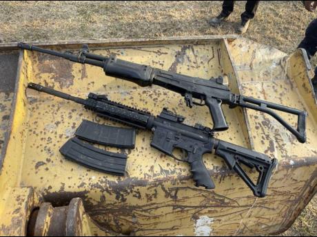 An AK-47 and an M16 rifle - two of the eight guns found at the Stadium East field in St Andrew earlier this year.