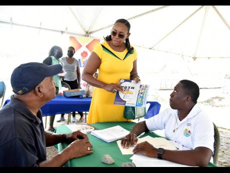 Member of Parliament for East Rural St Andrew Juliet Holness speaks with John Issacs (left) and Dexter Phillips from the Ministry of Labour and Social Security. 