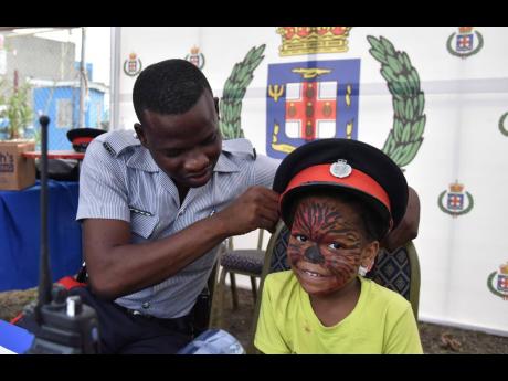 Benjamin Angus is overjoyed while Constable Steve Tyndale fits his hat during a social services health fair held at Donald Quarie High School on Saturday, April 30.