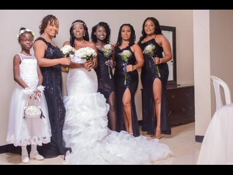 The beautiful bride wore an exquisite mermaid wedding gown from Unions Bridal Boutique, detailed with a sweetheart neckline and a ruffled train. She is joined by (from left) flower girl Keturah black, maid of honour Jonique Lewis, and bridesmaids Sonya Tit