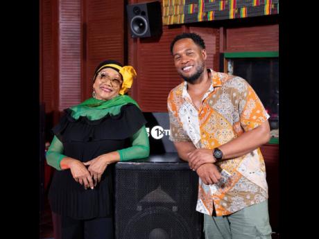 A smiling Reggae Queen Marcia Griffiths proudly wears her black, green and gold as she poses with BBC 1 Extra boss, Faron McKenzie. 