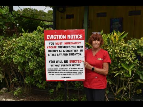 Suzan McKenzie, a business owner, shows her eviction notice that was erected on her property at Little Bay, Westmoreland.