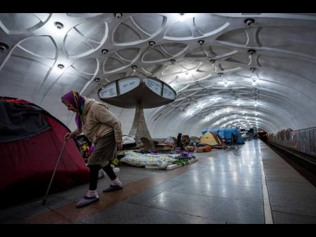 An elderly woman walks inside a metro station being used as a bomb shelter in Kharkiv, Ukraine, yesterday.
