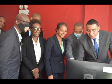 Prime Minister Andrew Holness (right) and other officials inspect some of the equipment at the newly opened Jamaica Fire Brigade (JFB) Area Four headquarters in Montego Bay, St James, following a handover ceremony yesterday. Also pictured are (from left) L