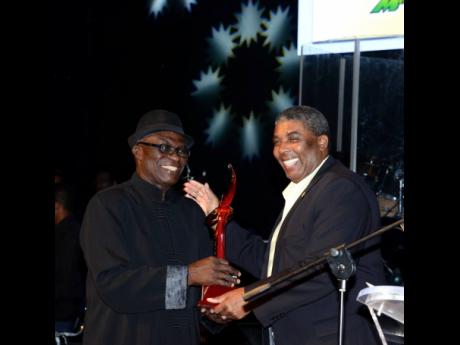 
Leon Mitchell (right) of Jamaica National Building Society presents Winston ‘Sparrow’ Martin with his JaRIA Honour Award at the ceremony held at the Courtleigh Auditorium in February 2014.