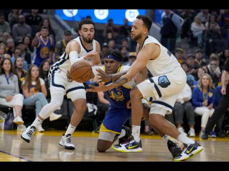 Golden State Warriors centre Kevon Looney (centre) reaches for the ball against Memphis Grizzlies’ Tyus Jones (left) and Kyle Anderson during the first half of Game 6 of an NBA basketball Western Conference play-off semi-final in San Francisco on Friday.