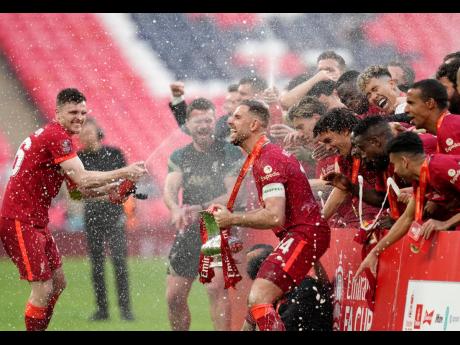 
Liverpool players celebrate at the end of the English FA Cup final soccer match between themselves and Chelsea at Wembley stadium, in London yesterday.