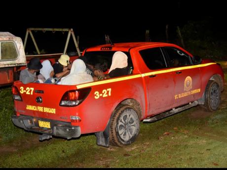 Seven university students being taken away to be reunited with their parents in a Jamaica Fire Brigade vehicle from Irwin Riverside in Montego Bay. 