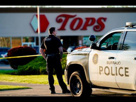 A police officer stands guard outside the scene of a shooting at a supermarket, in Buffalo.
