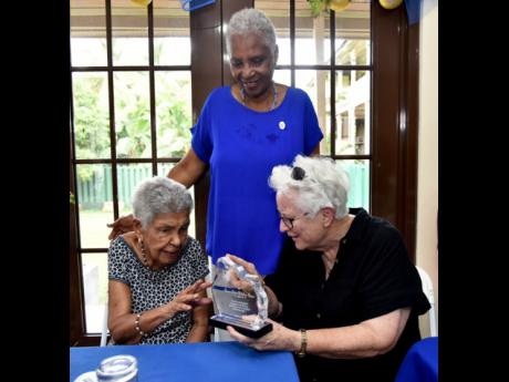 Marcia Thwaites (centre) looks on as Sister Susan Frazer (right) presents a plaque to 103-year-old Carmen Elaine Robertson Brown, the Convent of Mercy Academy’s oldest living graduate. 