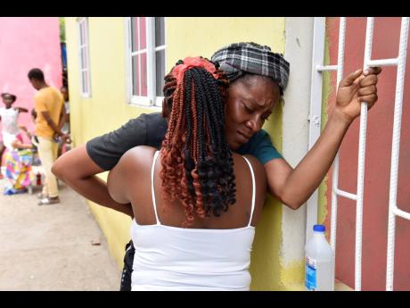 Kristal Facey (back to camera) comforts Latoya Thompsom, the mother of the 17-year-old who allegedly stabbed his brother, Alex Brissett, to death in Tawes Meadows on Saturday. The alleged attacker is on the run. 