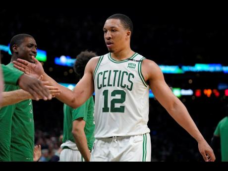 Boston Celtics forward Grant Williams (12) celebrates with teammates while approaching the bench  during the second half of Game 7 of a NBA basketball Eastern Conference semi-finals playoff series in Boston yesterday.  The Celtics won 109-81. 