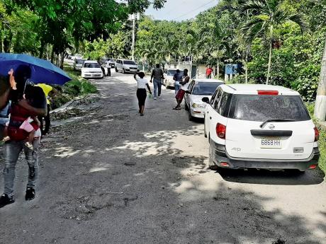 Cars parked near the protest action yesterday as the blocked roads forced many commuters to find an alternative route, abandon their journey or continue along the blockaded road by foot.