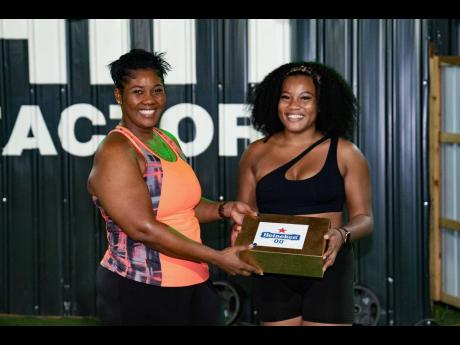  Alae Jumpp (right) proudly received her first-place prize of a three-month Express Fitness Platinum membership and other goodies from Red Stripe Brand & Corporate PR Manager, Stacy-Ann Williams-Smith.