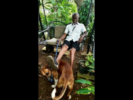 Fitzroy Buchanan, 95, plays with his best friend at his home in Coral Springs, Trelawny.