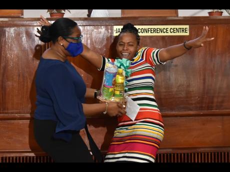 Melicia Mathison (right), principal of Constitution Hill Primary and Infant School, is a picture of excitement upon accepting the Brain Builders Centre of the Year award from Tanketa Chance-Wilson on Monday.